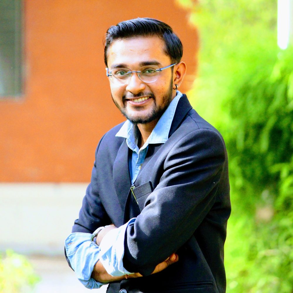 portrait-smiling-young-man-standing-with-arms-crossed